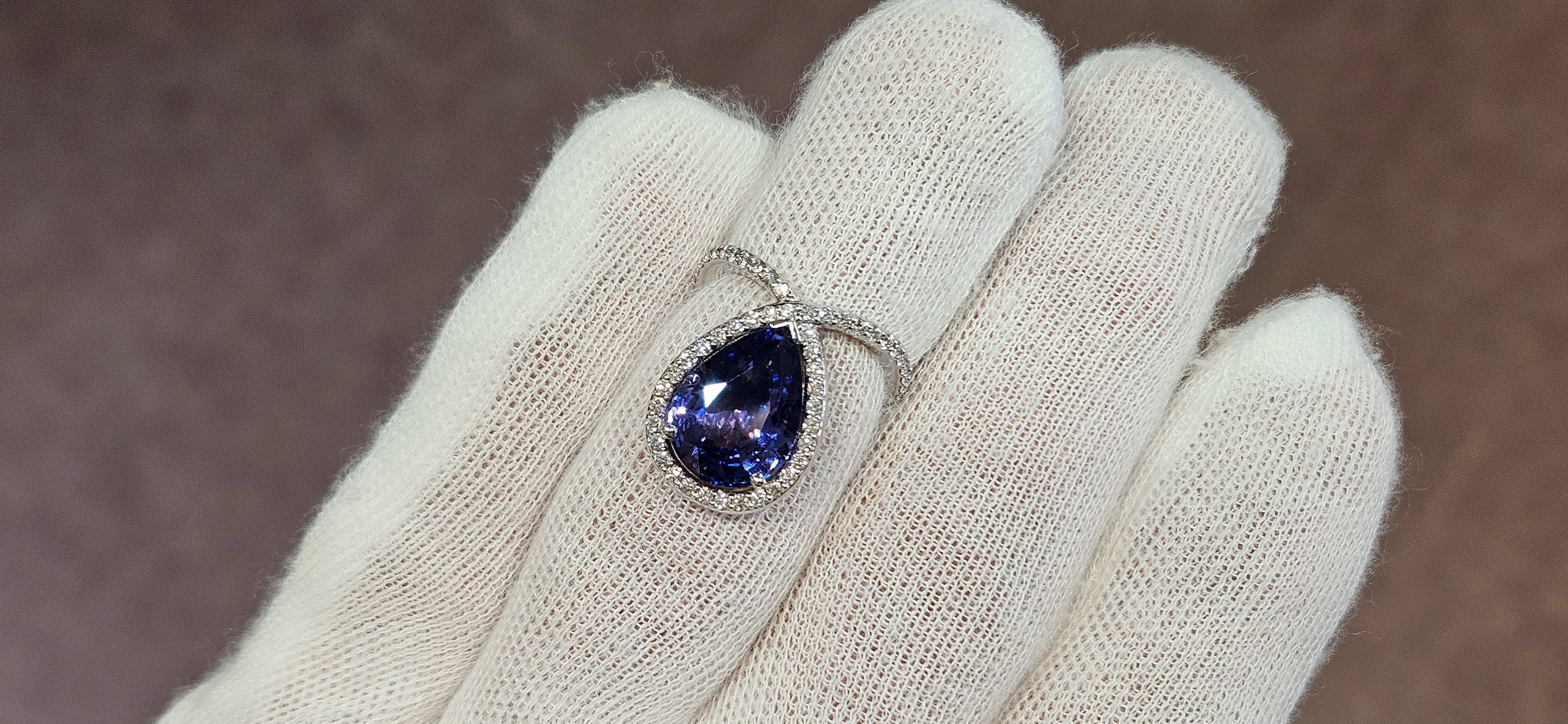 18k White + Yellow Gold with a Ceylon Purple Blue Sapphire Sounded in a Unique Diamond Swirl.