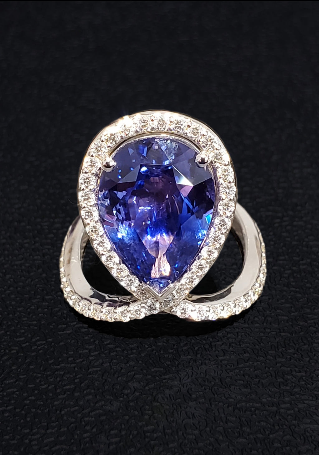 18k White + Yellow Gold with a Ceylon Purple Blue Sapphire Sounded in a Unique Diamond Swirl.