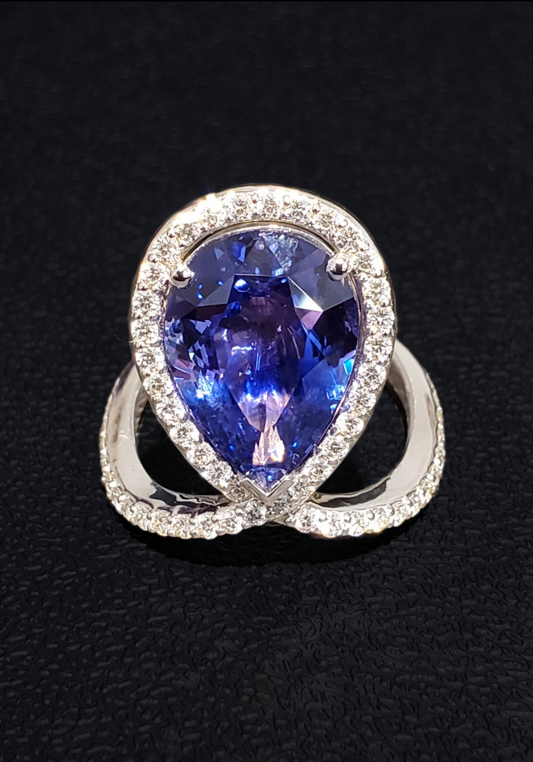 18k White + Yellow Gold with a Ceylon Purple Blue Sapphire Sounded in a Unique Diamond Swirl.